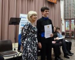 Paul Owen-Dugdale is presented with the winner's certificate Rotary District 1150's Assistant Governor Maggie Hughes PHF Presenting the awards